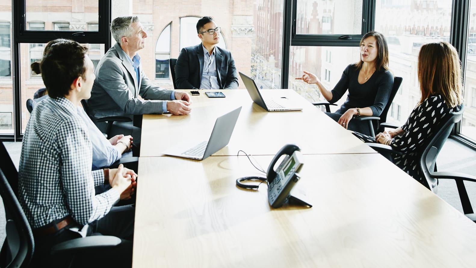 Male and Female coworkers discuss topics in a conference room